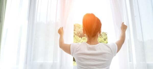 Woman looking out of clean windows in Albury Wodonga